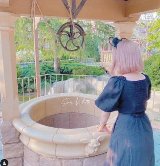 우물 앞에 여성이 서 있는 뒷 모습