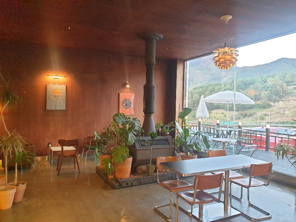 중앙에 벽난로가 보인다. 외부 창을 통해 산이 보인다.