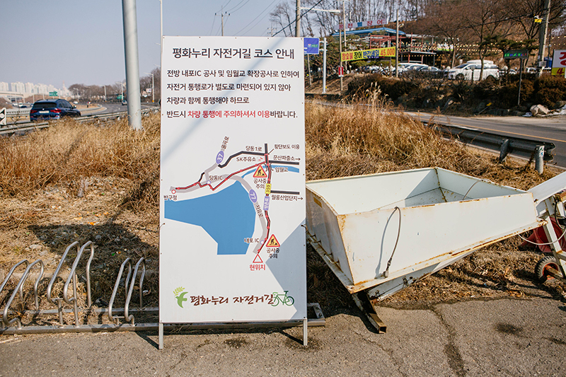 평화누리 자전거길 안내판. 인도가 없어 차도로 가야하며, 안전에 유의하면서 가라는 내용.