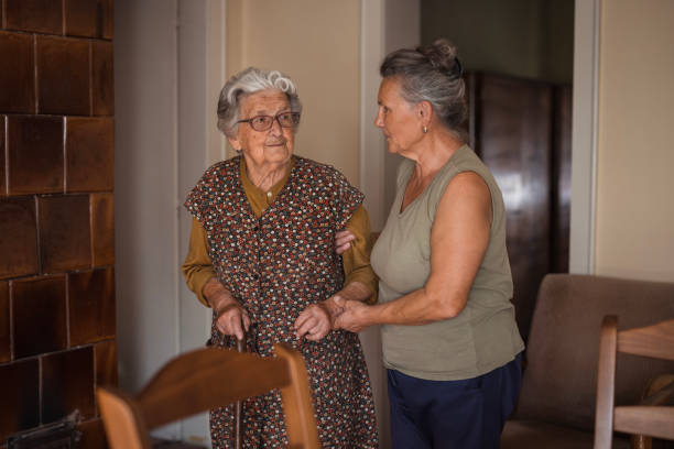 집안에서 지팡이를 잡고 걸어 나오는 듯한 할머니를 옆에서 부축하는 중년 여인의 모습으로&amp;#44; 가정에서도 누군가의 돌봄이 필요함을 보여주는 다른 예시 사진