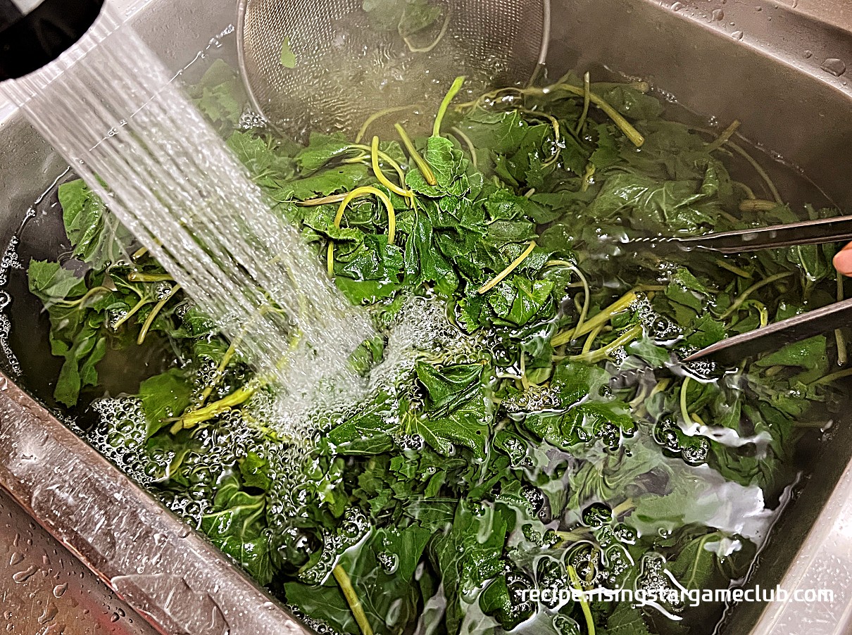 데쳐진 머위를 찬물에 씻는 사진