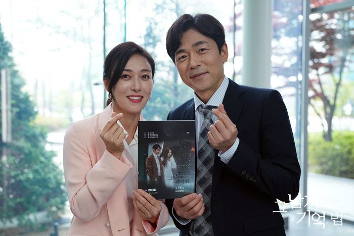 작품 인쇄물을 들고 손가락 하트를 만드는 장영남과 이승준