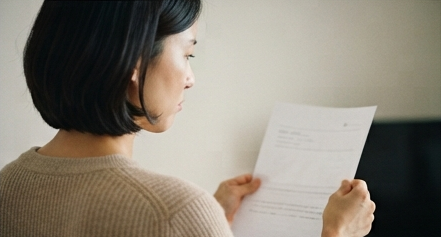 성적표를 보며 살짝 미간을 찌푸리는 엄마의 뒷모습 사진