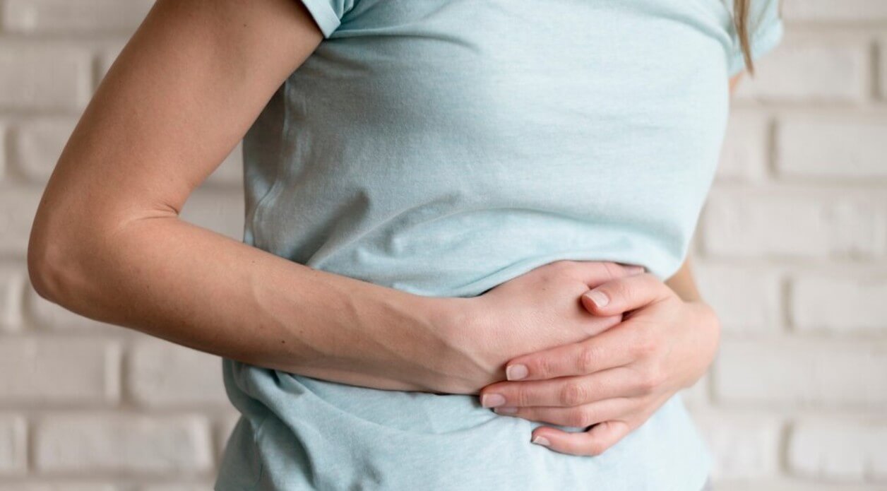 배를 잡고 있는 여성