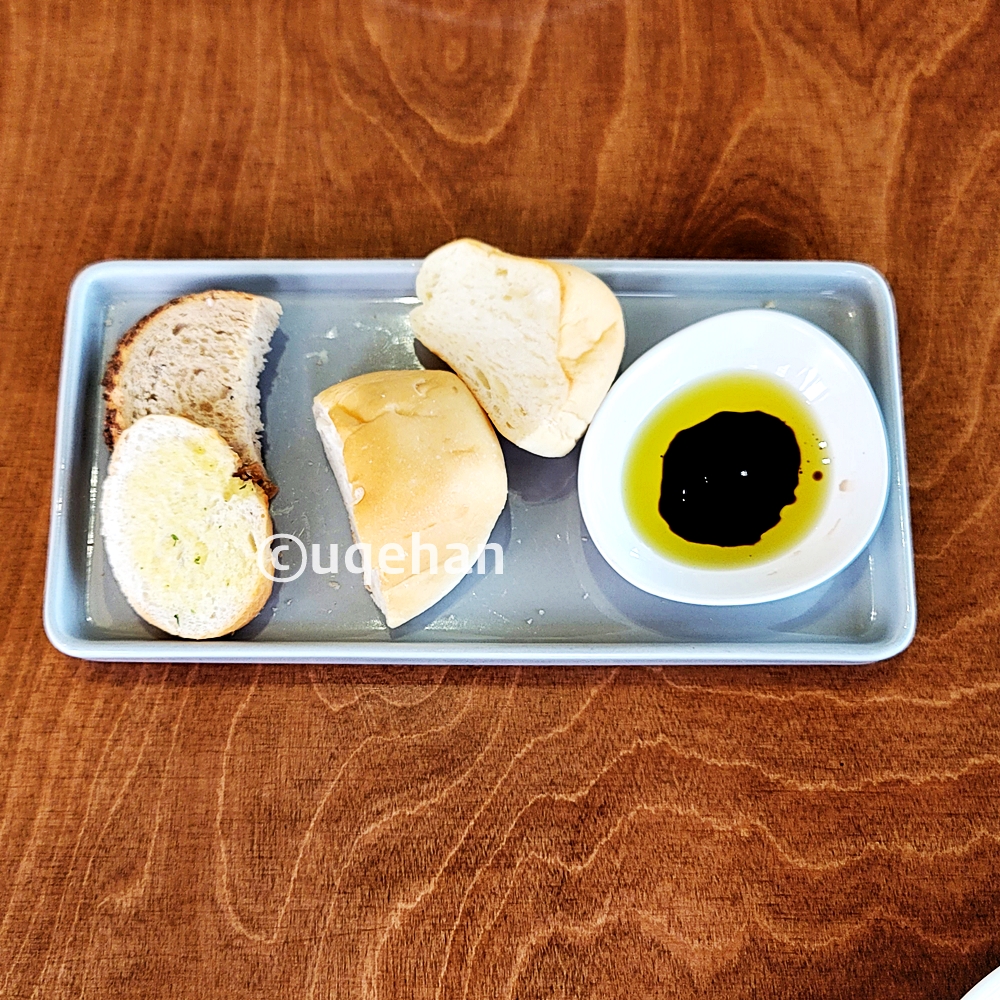 접시위에 빵 4조각과 작은 접시위에 올리브오일 그리고 발사믹소스가 들어있다.