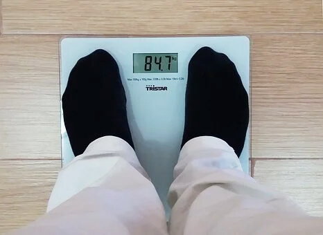 체중계에 올라와 있는 남성의 발과 숫자 표시