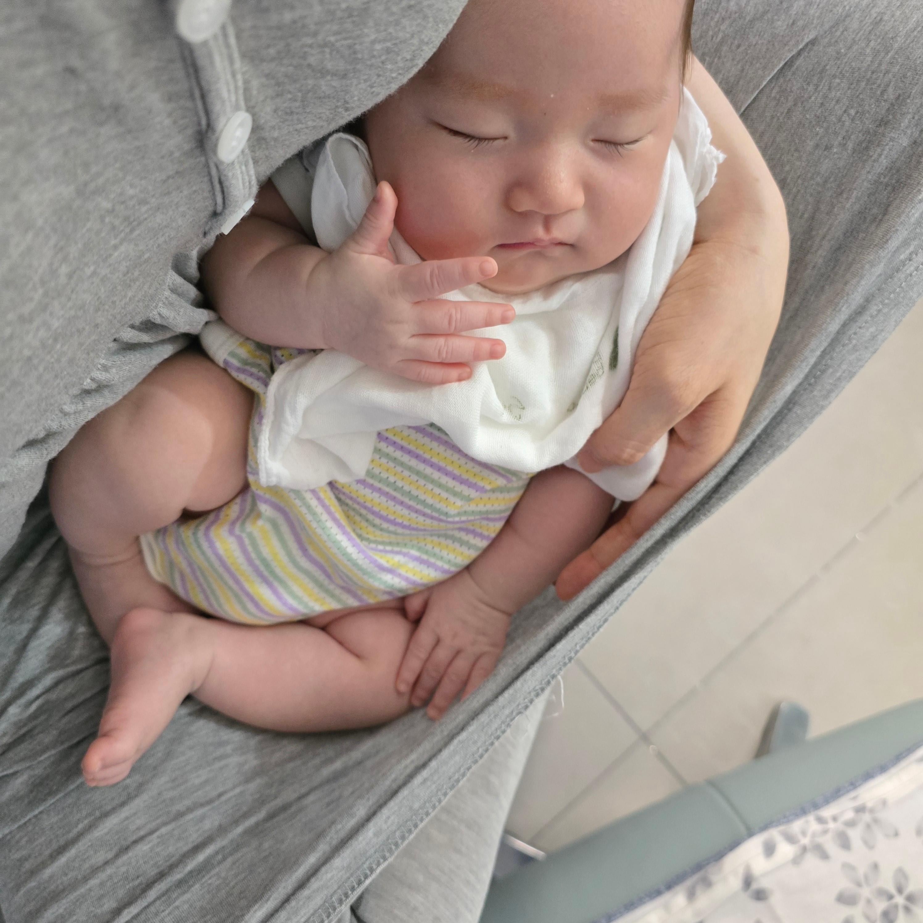 엄마에게 안겨서 자는 신생아