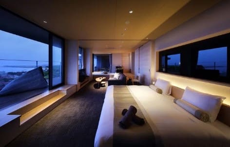 넓은 침대가 큰 창문을 마주보고 설치되어 있다.