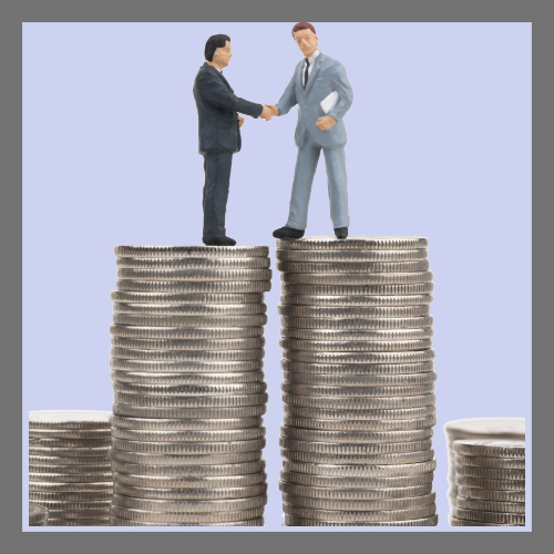 쌓여진 동전위에 악수를 하고 있는 정장입은 두 남성