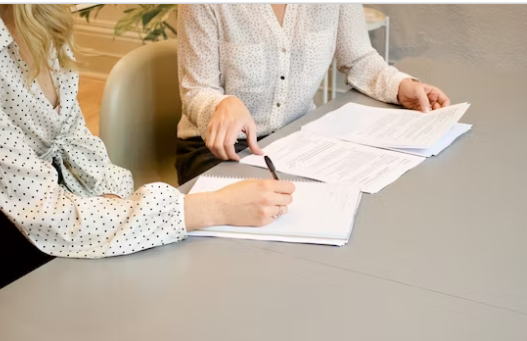 두-여자가-계약서에-사인을-하고-있다