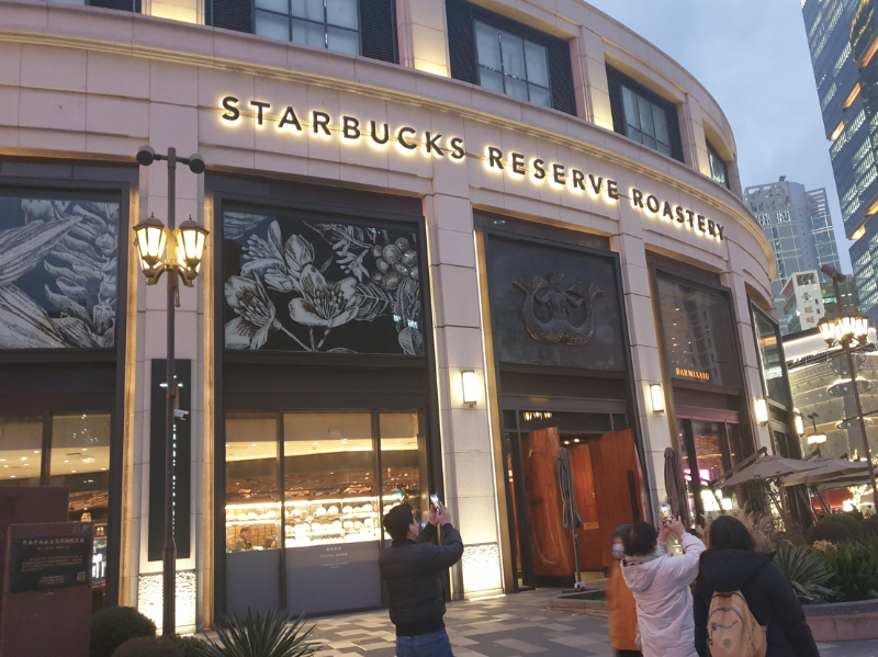 원형 건물 스타벅스 리저브 로스터리 앞에서 사진을 찍는 사람들