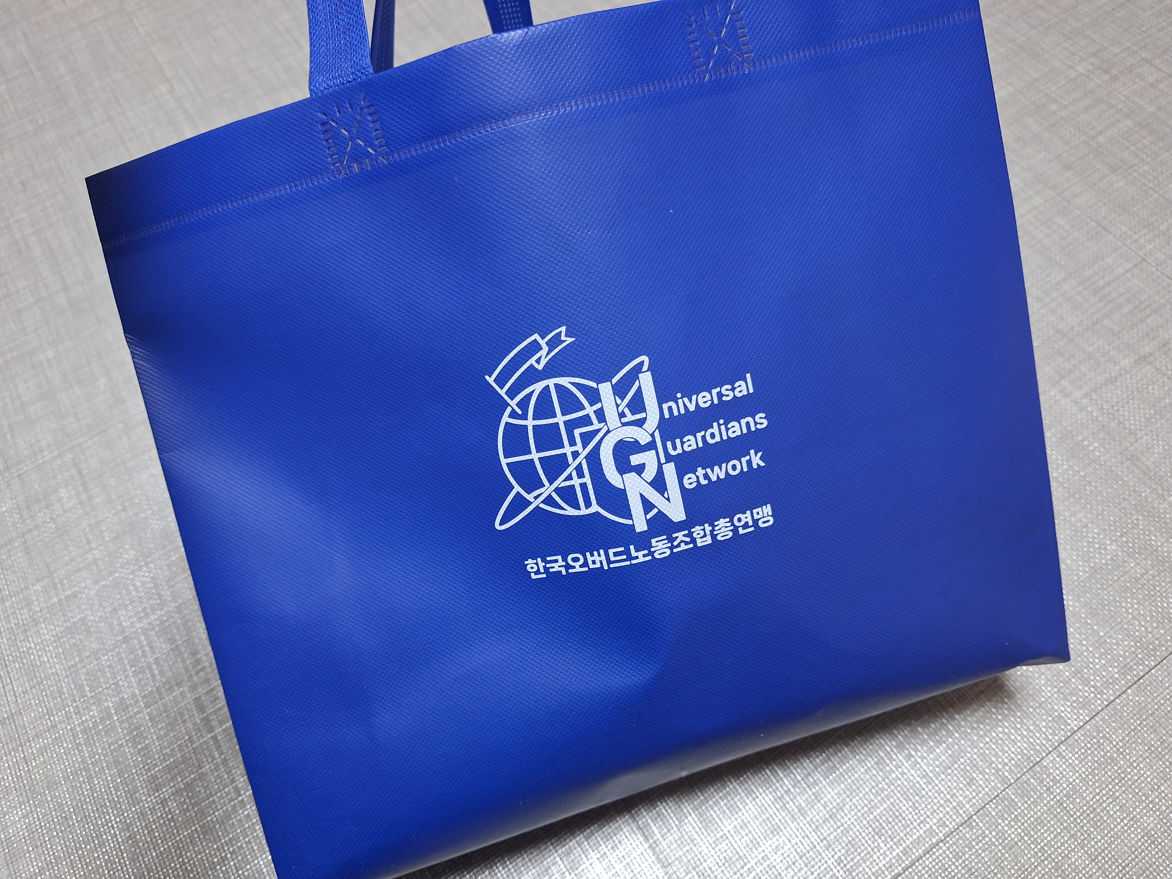부직포 가방. '한국오버드노동조합총연맹'이라는 글귀가 적혀 있다.