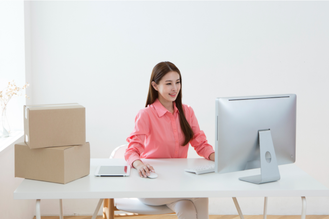 한 여성이 컴퓨터로 일을 보고 있다.