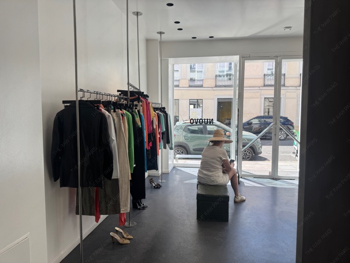 The minimalist interior of Nuovo vintage shop in Le Marais Paris with clothing racks ❘ L'intérieur minimaliste de la boutique vintage Nuovo à Paris