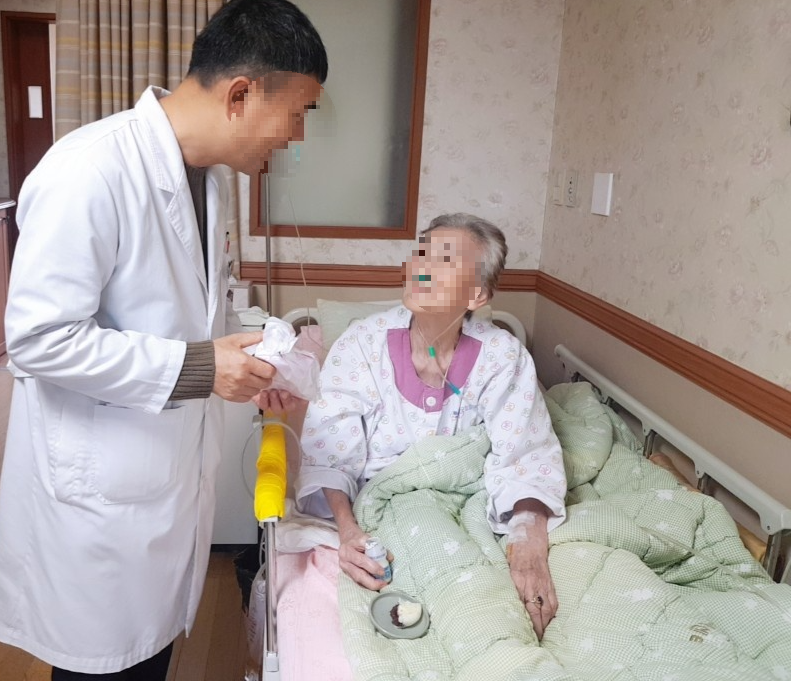 호스피스 환자의 안색과 상태를 살피는 호스피스전문의사