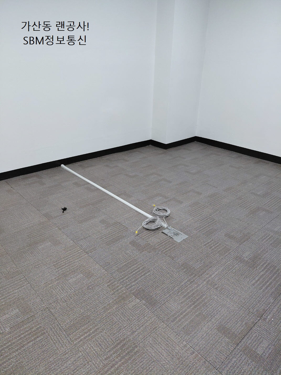 바닥 타일 색상과 조화되는 화이트 톤의 몰딩을 사용하여 일직선으로 곧게 뻗은 깔끔한 배선 처리 모습