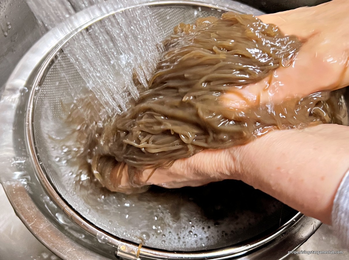 냉면 면을 찬물에 문질러서 씻는 사진