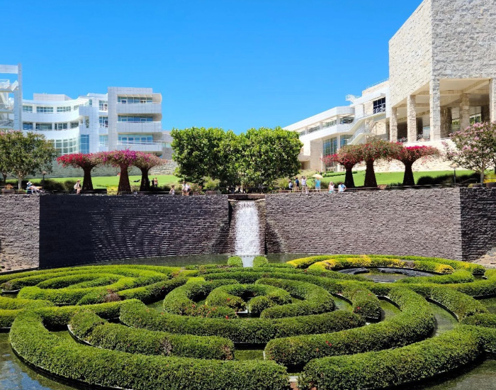 게티 센터 정원 안에서 바라본 모습. 낮은 풀나무가 미로 모양으로 되어 있다. 정원 끝에는 벽이 있고&amp;#44; 그 위로 잔디밭과 나무들이 좌우대칭을 이루고 있고 그 뒤로 게티 센터 건물이 보인다. 