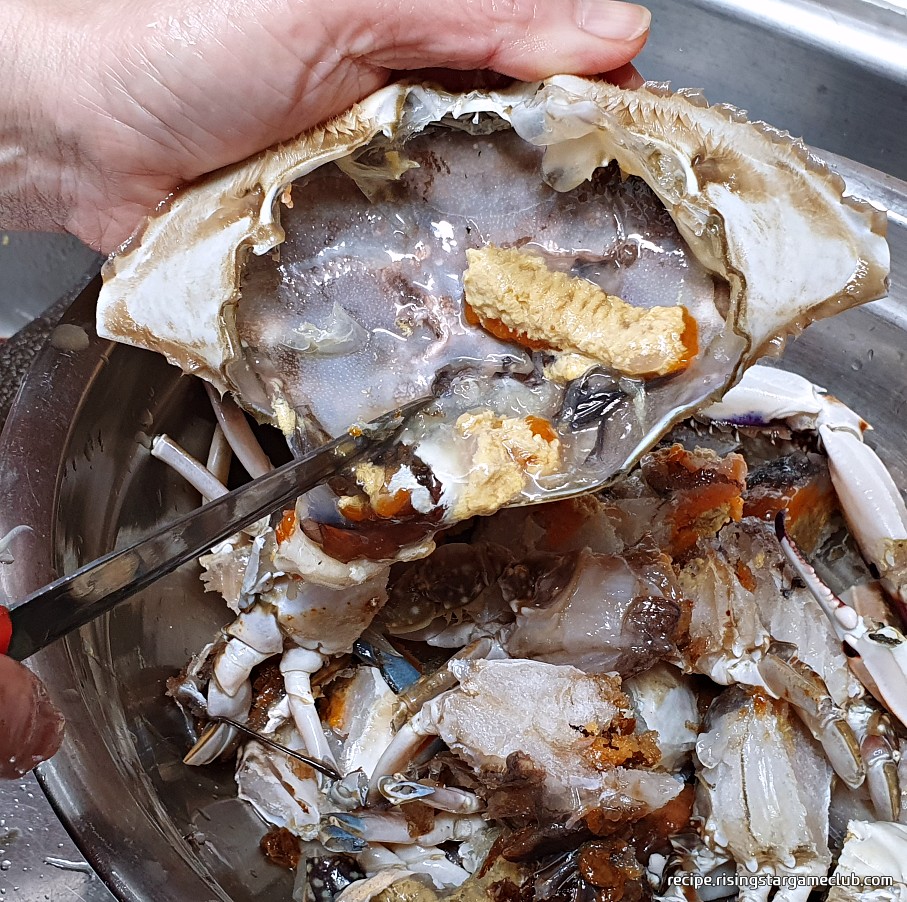 맛있는 양념게장에 들어갈 꽃게의 딱지 안에 들어있는 살들을 양푼에 긁어서 모으는 사진
