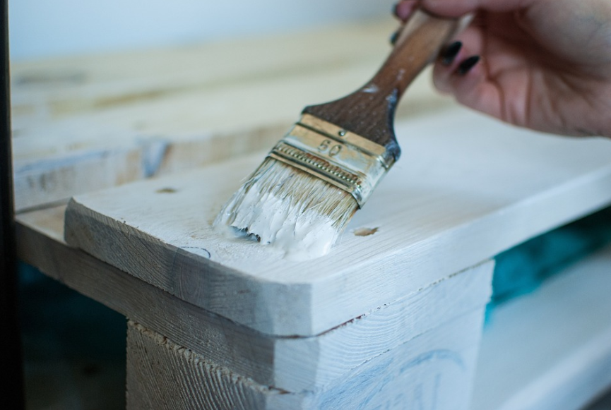 방수 페인트 : 나무에 하얀색으로 페인트 붓으로 칠을 하고 있다