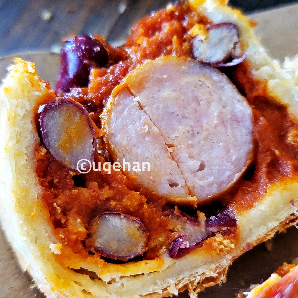 카페 럿지 칠리소시지사진이다. 빵 안에 큰 소시지가 들어가있고 그 사이에 칠리소스와 강남콩이 어우러져있다.