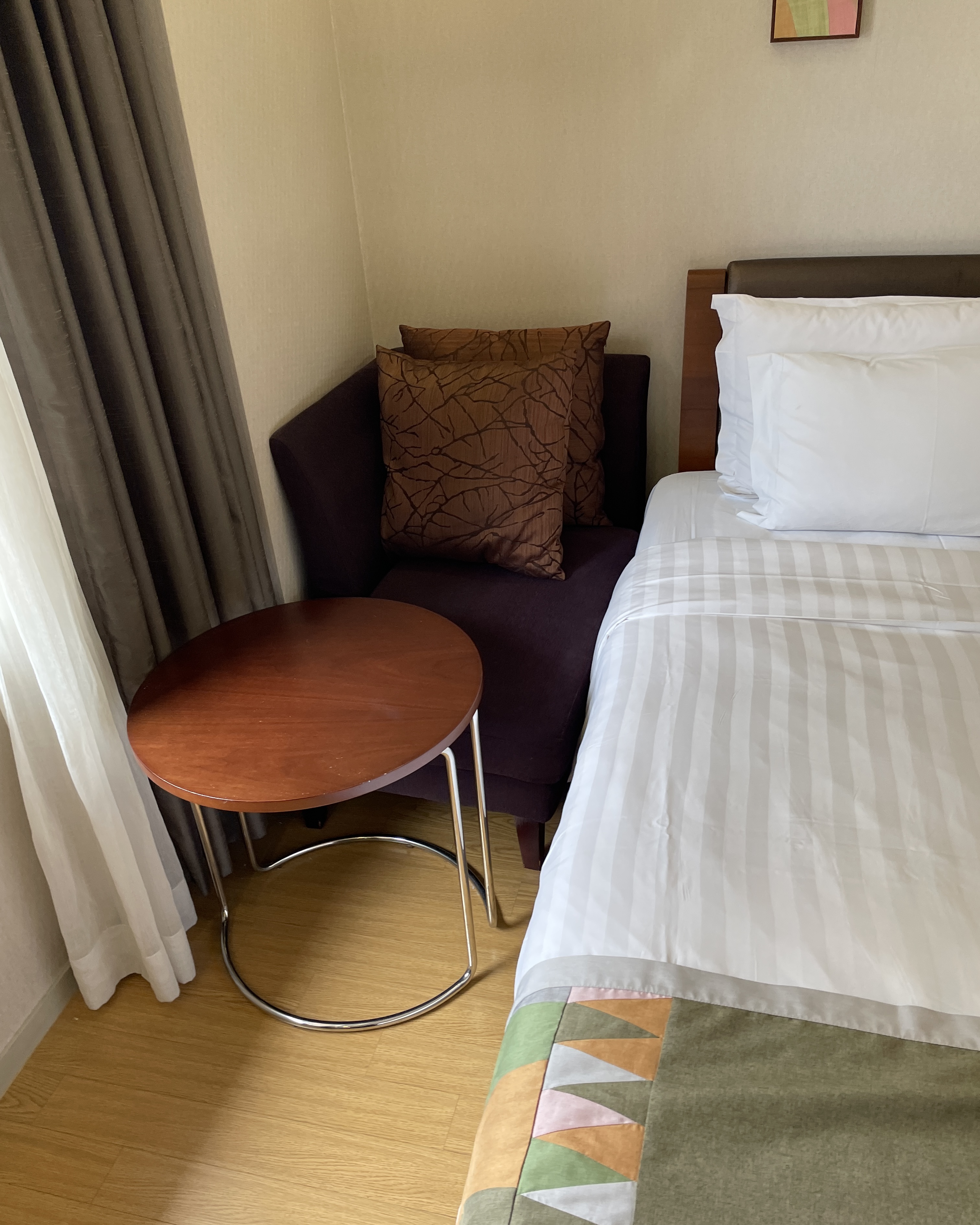 침실 한편에 1인용 소파와 테이블이 있다.