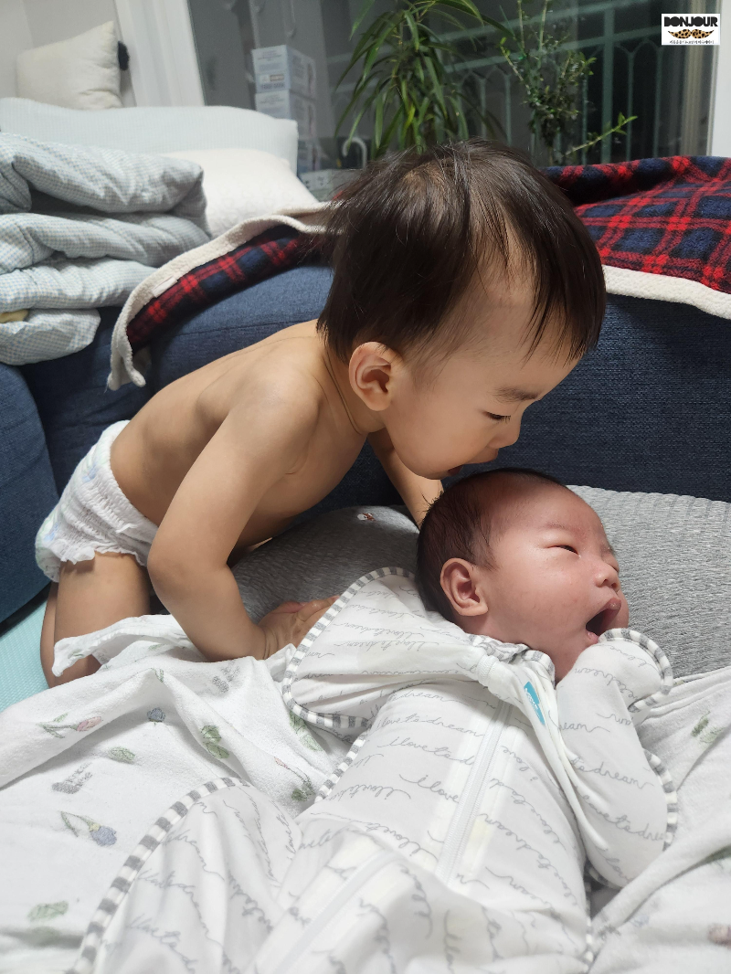 동생을 깨무려는 듯한 포즈를 취하고 있는 17개월 첫째아기