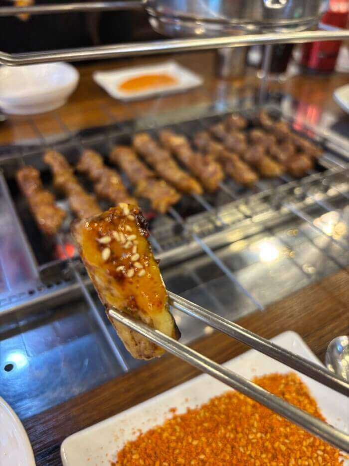 젓가락이 집고 있는 쯔란을 찍은 양꼬치