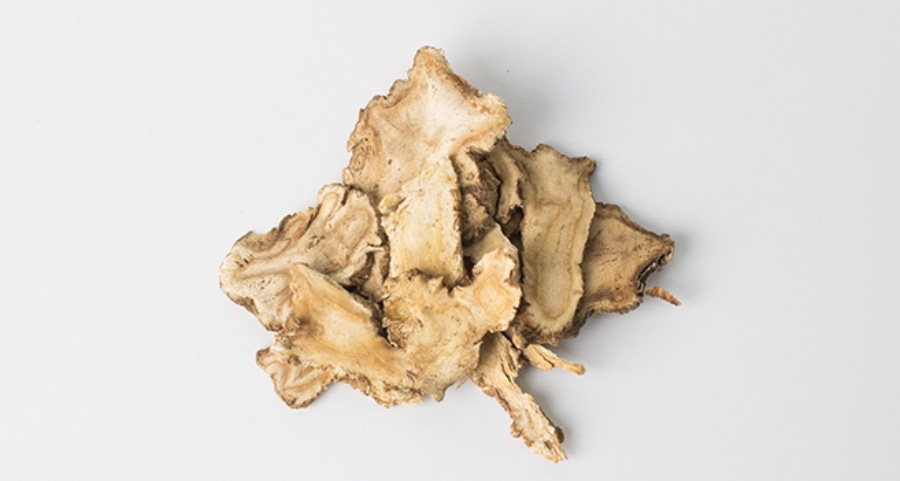 야생에서 채취를 한 백지를 깨끗하게 세척하고 건조시킨 것을 편으로 썰어서 하얀 바닥 위에 수북하게 놓아두고 찍은 사진