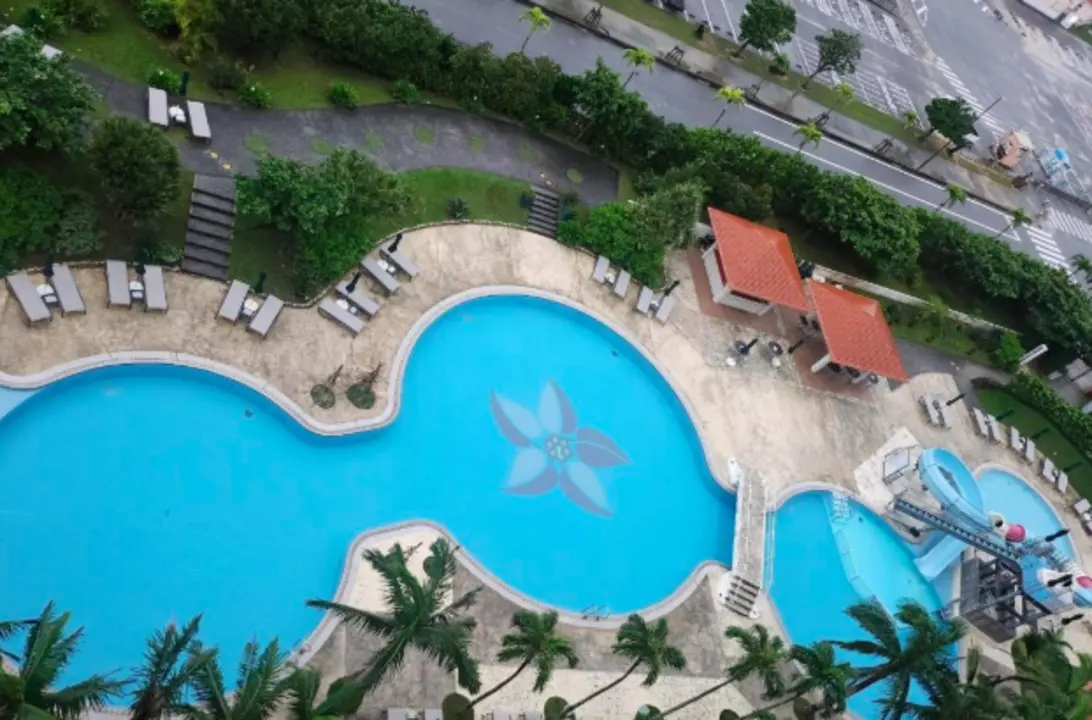 Outdoor swimming pool at Southern Beach Hotel & Resort with ocean view and palm trees