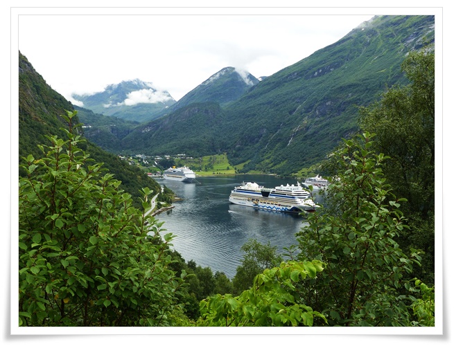 웅장한 초록빛 계곡으로 둘러싸인 노르웨이 피오르드에 크루즈선들이 정박해있는 풍경