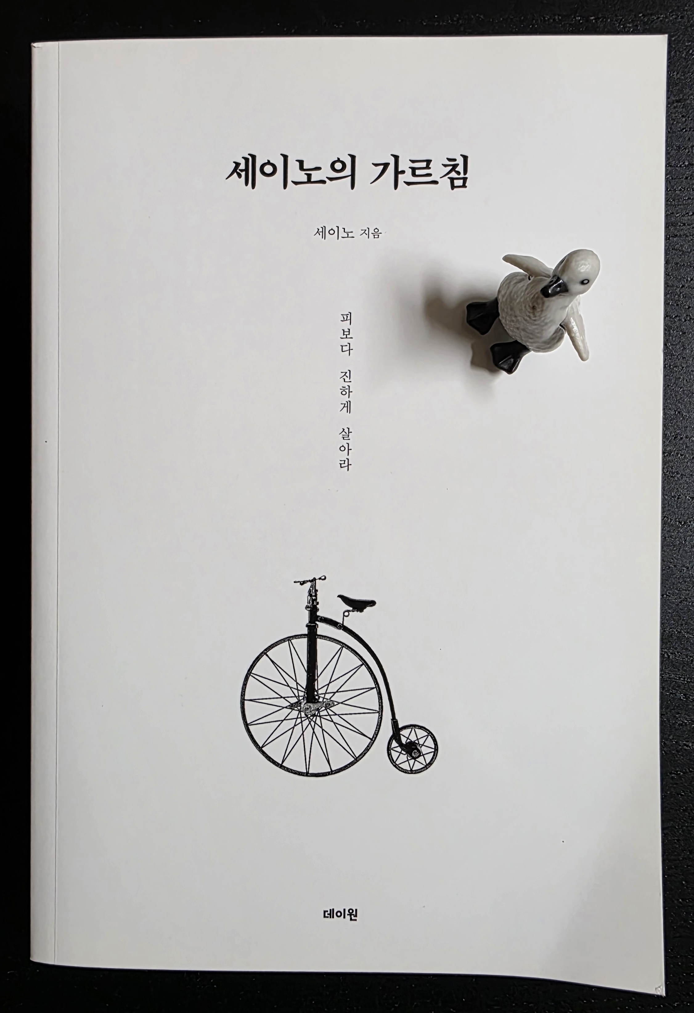 펭귄 피규어가 올려진 세이노의 가르침 책 표지