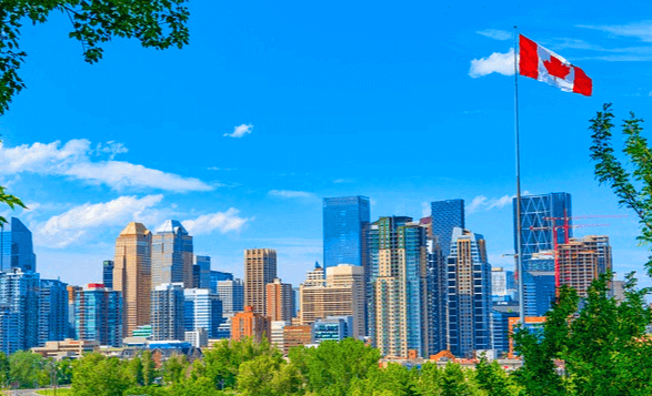 캐나다 도시 풍경이다. 수많은 빌딩들이 즐비하고 파란 하늘엔 캐나다 국기가 날린다.