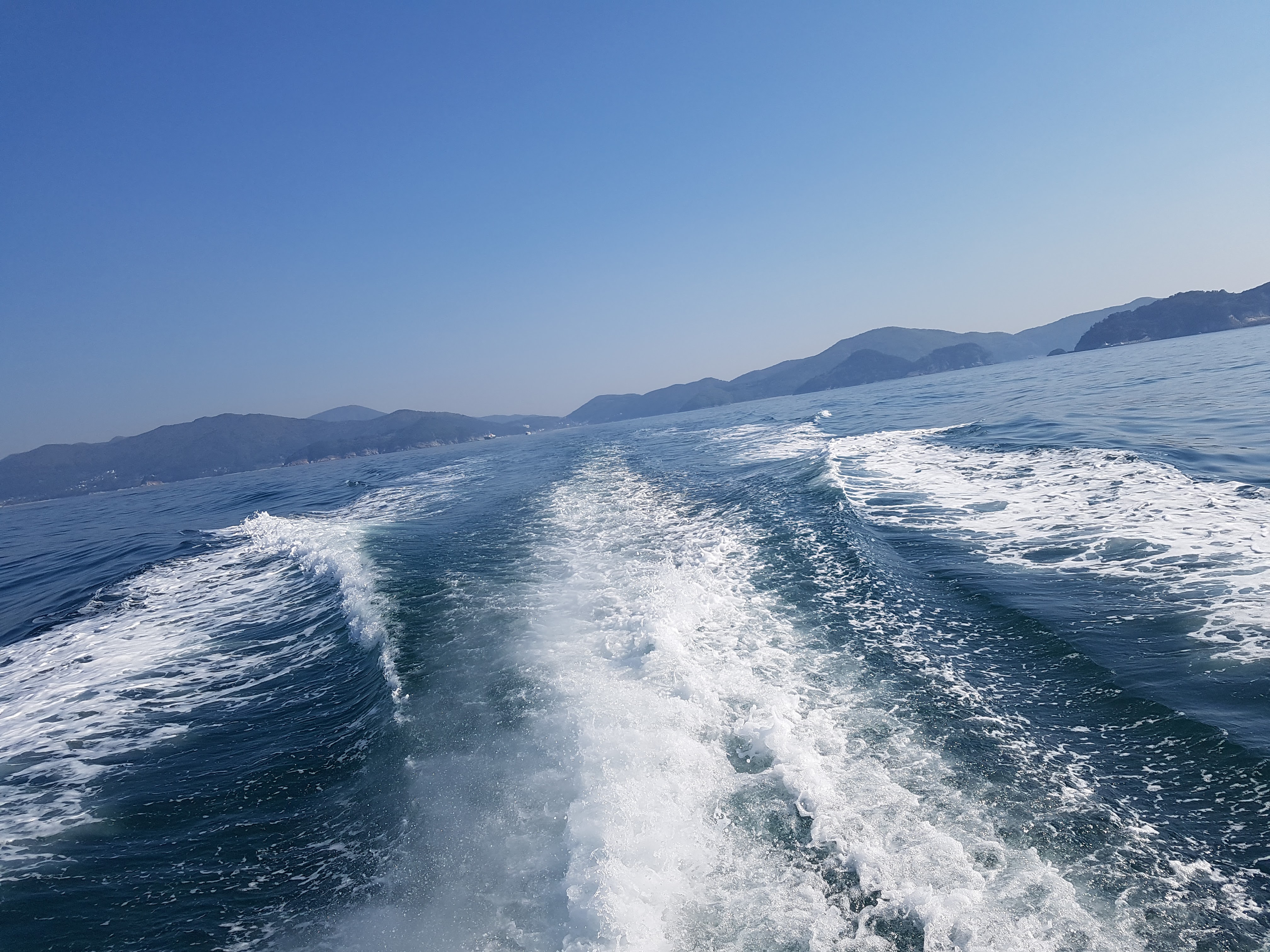 푸른 거제도 바다 위를 유람선이 하얀 물보라를 일으키며 달리는 시원한 풍경