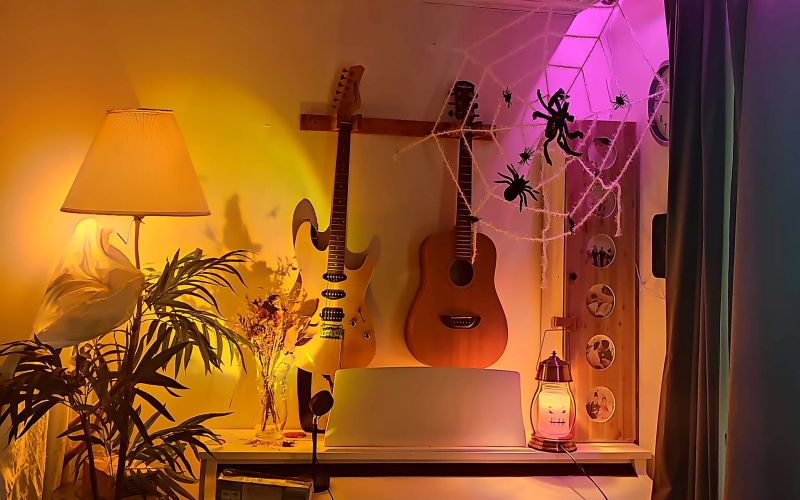 왼쪽부터 하얀천을 씌운 거실등 마녀가나는 선셋조명 괴물 향초 거미줄 위로 샤오미 이라이트로 핑크색 조명을 쏴주어 분위기 있는 거실 인테리어