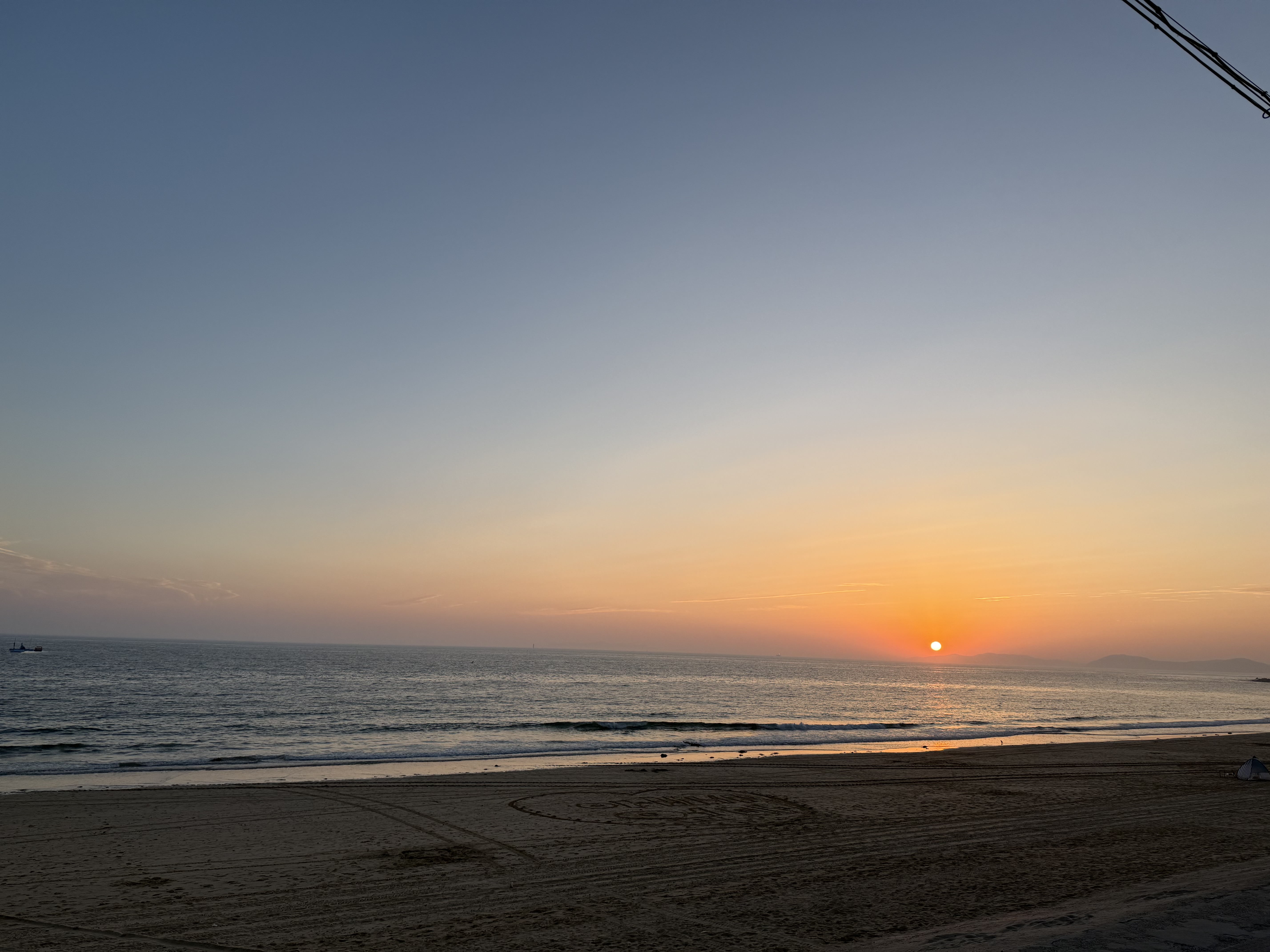 해가 천천히 바다아래로 사라지기 직전 파란 하늘 아래 붉은 석양이 아름답게 물들고 있습니다.