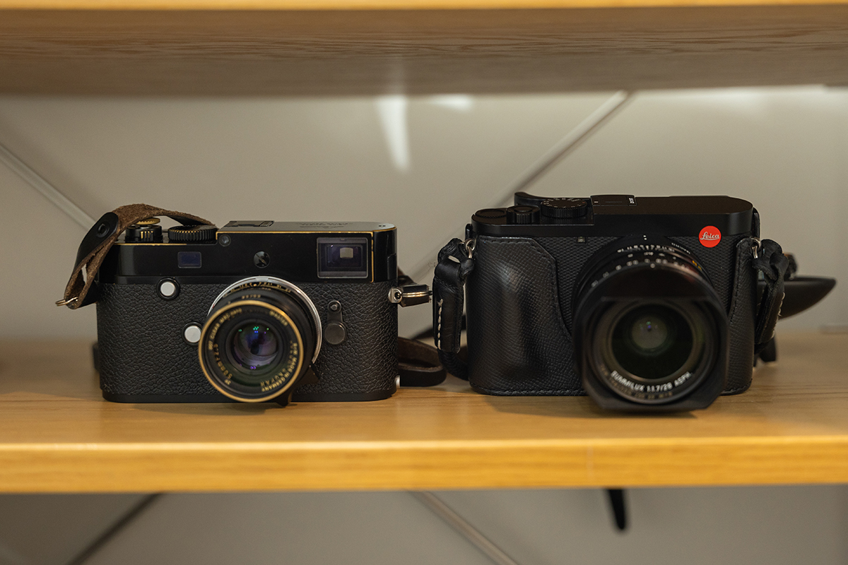 선반 위에 나란히 놓인 라이카 M-P(Typ 240) 블랙 페인트 바디와 라이카 Q2 카메라의 정면 비교 모습