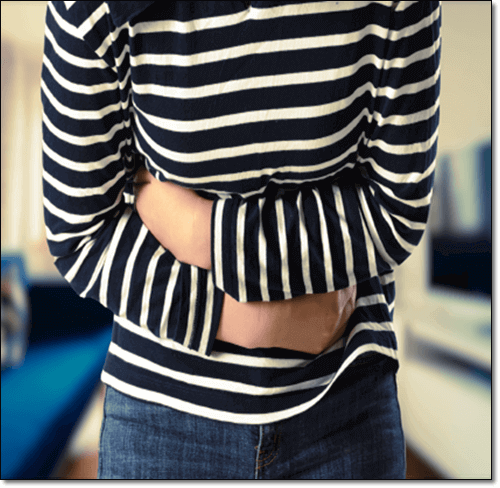 배를 부여 잡고 있는 복통이 심한 여성