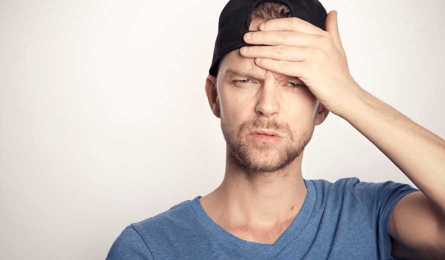 하품이 자주 나오는 이유로 편두통으로 이마에 손을 얻고 있는 남자