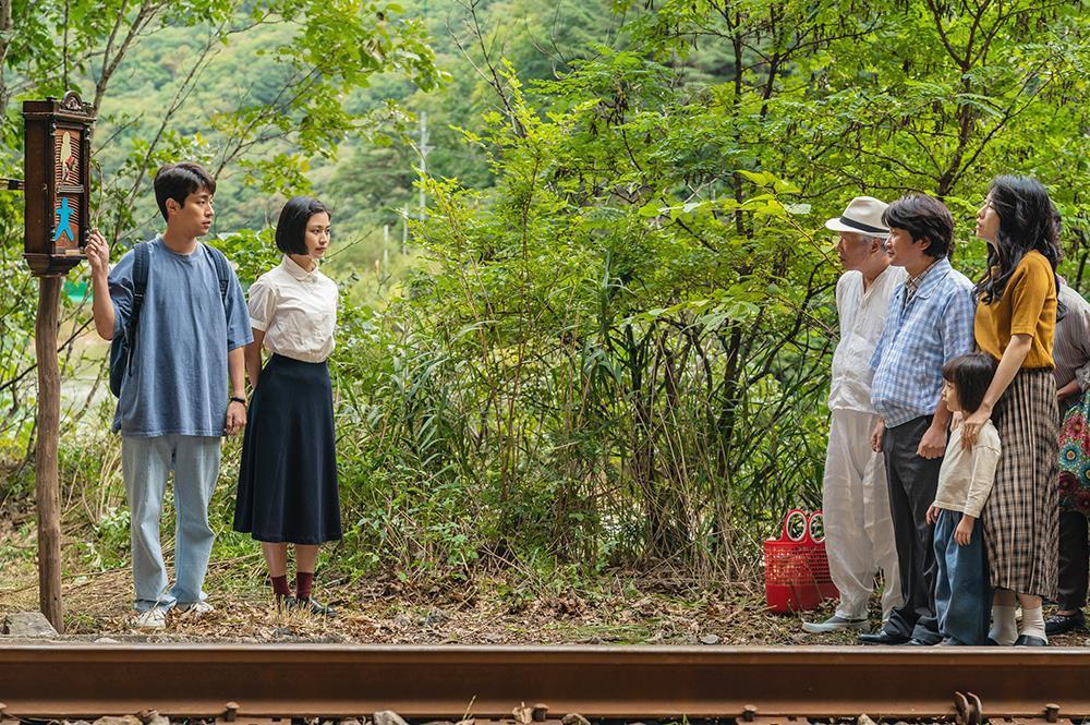 사람들이 기찻길에 서있는 모습