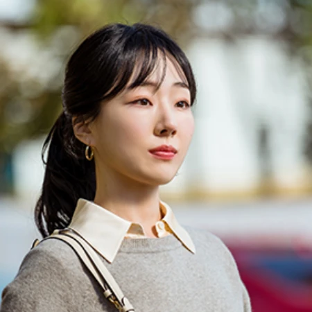 어느 실외에 갈색 티셔츠에 검은 긴머를 포니테일로 묶은 오늘도 사랑스럽개의 천송이 캐릭터