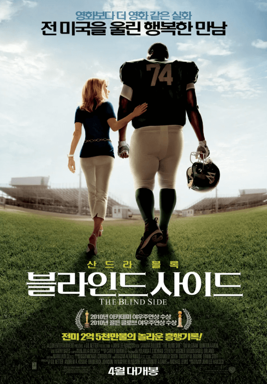 영화 블라인드 사이드 포스터. 리 앤 투오이와 마이클 오어의 뒷모습. 투오이가 오어의 등을 쓰다듬고 있는 따뜻한 모습이다.