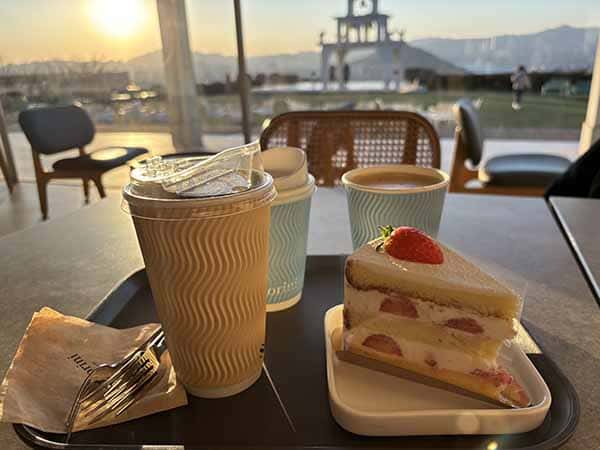 딸기 케이크와 커피, 창밖 노을 풍경