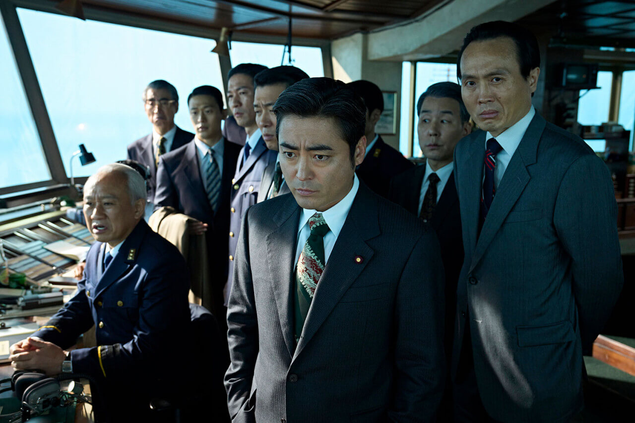 운수정무차관 신이치가 관제탑에서 상황을 지켜보며 인상을 찌푸리고 있는 모습