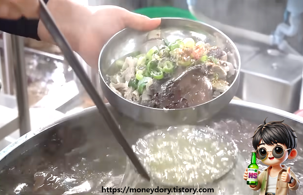 돼지국밥을 뚝배기에 끓이지 않고 냉면 그릇에 건더기를 담아 솥단지에 끓고 있는 육수로 토렴 중인 모습