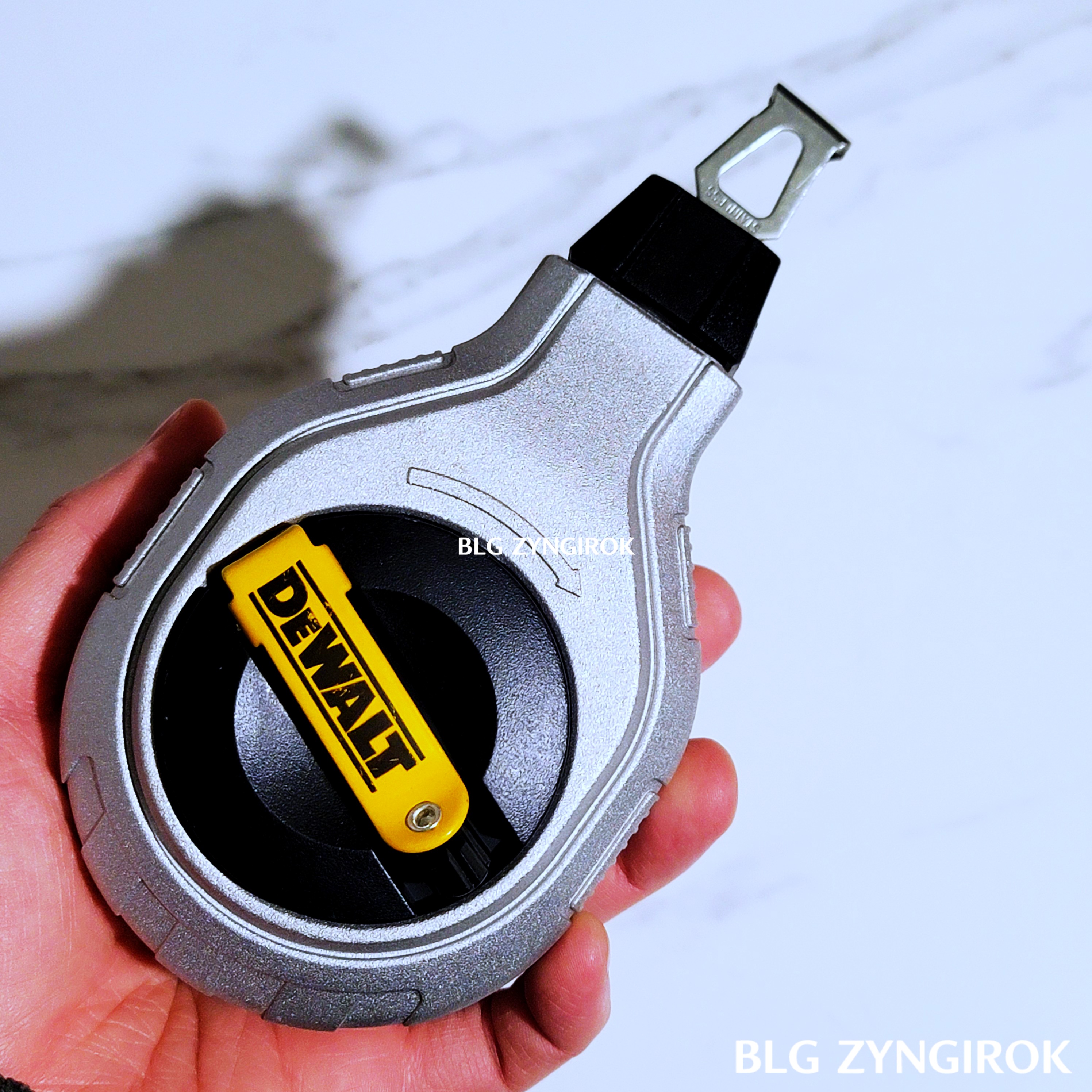 디월트-초크라인을-들고있는-모습이다.-손바닥보다-큰것을-알수있다.