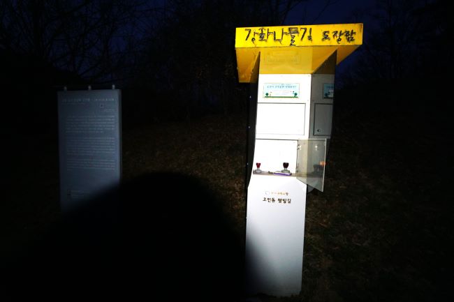 어둠에 묻힌 스탬프함, 함은 휜색 철제 사각통, 아마는 노란색 테두리,