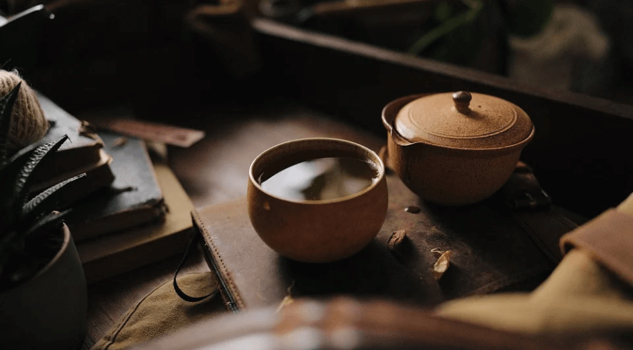 찻잔에 차와 주전자가 놓여 있다