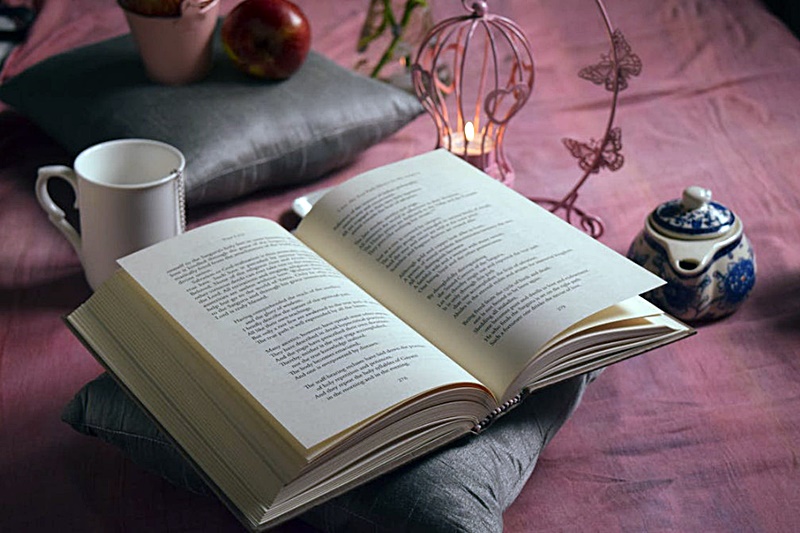 작은-조명과-커피-책이-펼쳐져-있는-모습