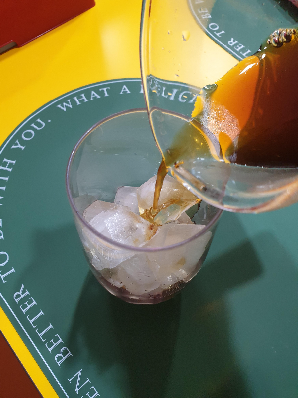 얼음이 담긴 컵에 칠링된 커피를 붓는 모습